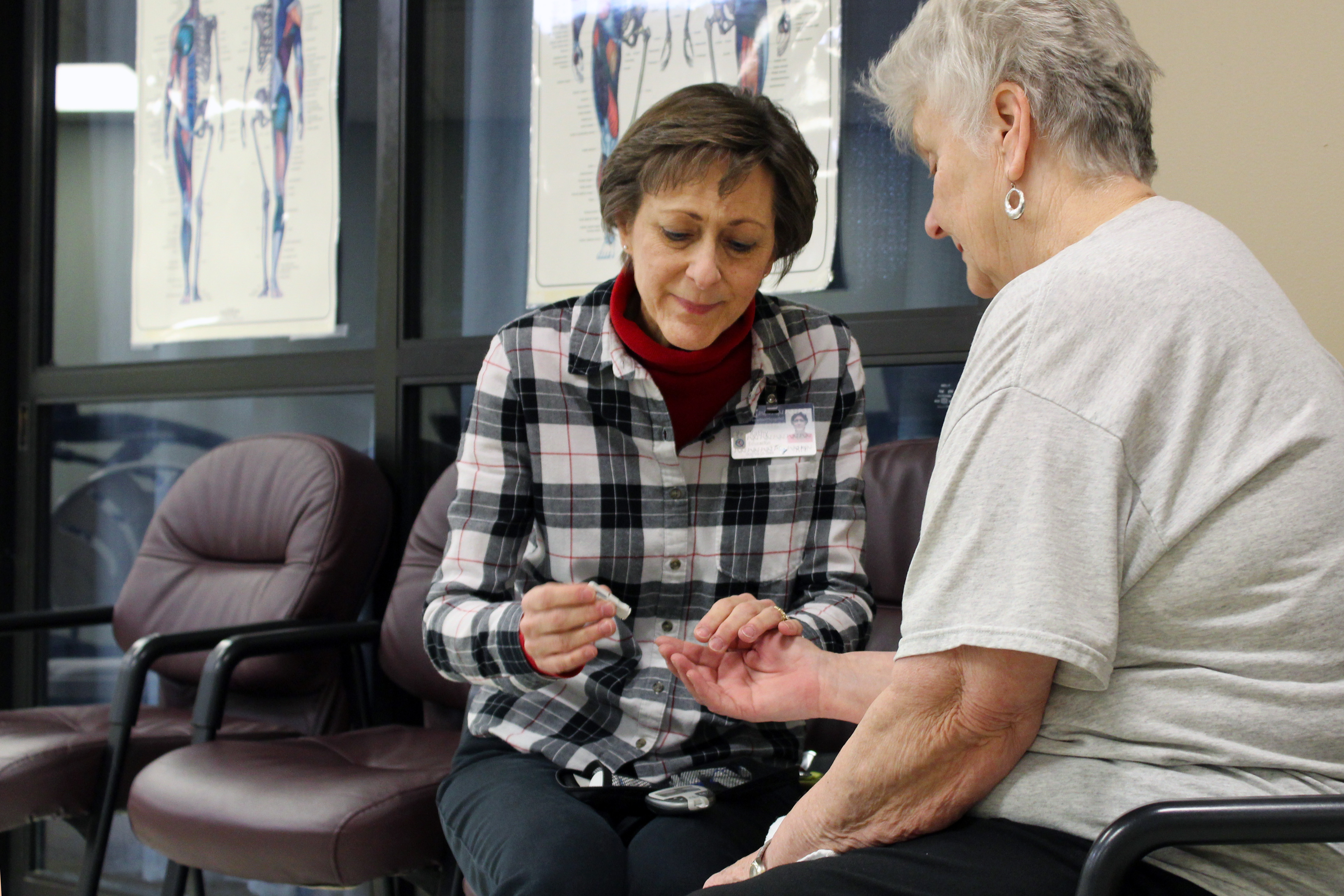 Kathy Strom helps a diabetic patient with a blood sugar test