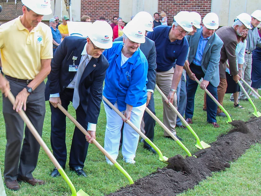 Board members shoveling dirt into a new construction project